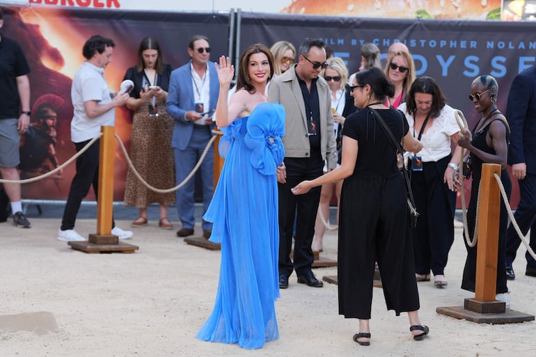 Anne Hathaway saluda a su llegada a la premier mundial de The Odyssey en Londres. (CARLOS JASSO / AFP)