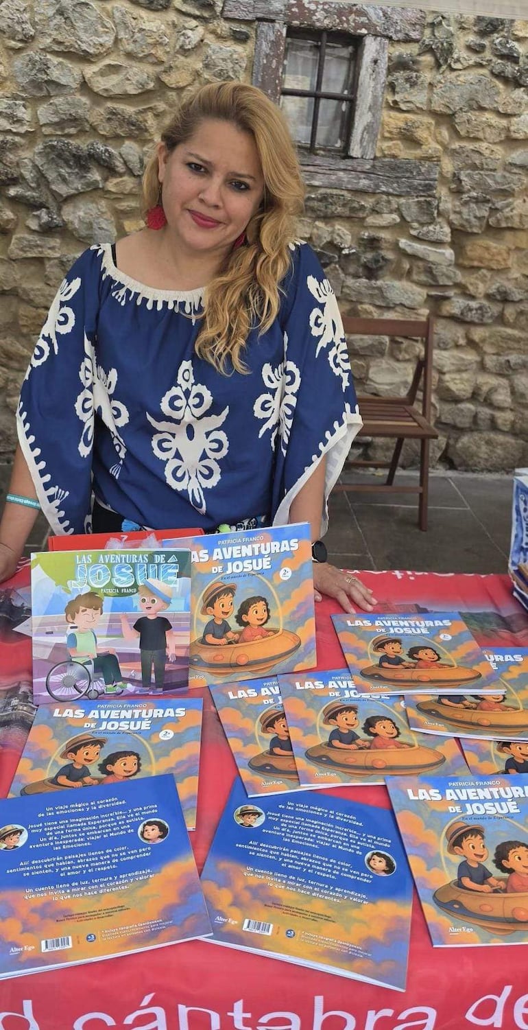 Patricia Franco, con blusa azul, frente a mesa con libros, en ambiente exterior con fondo de piedra.