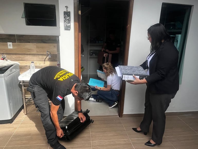 La fiscala Ruth Benítez y policías del Departamento Contra el Crimen Organizado verifican las intalaciones de la casa ubicada en Roberto L. Pettit.