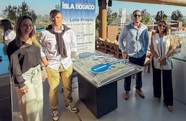 Cuatro personas, vestidas formalmente, observan un modelo arquitectónico en la terraza de la Torre Seminario.