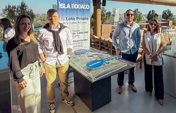 Cuatro personas, vestidas formalmente, observan un modelo arquitectónico en la terraza de la Torre Seminario.