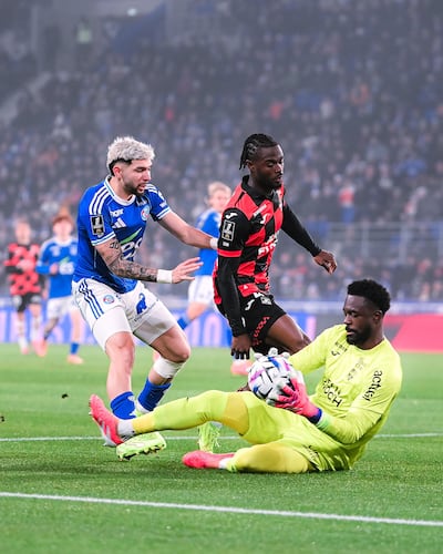 El portero suizo de Lorient, Yvon Mvogo se anticipa al intento ofensivo del delantero paraguayo Julio Enciso del Racing Estrasburgo