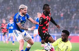 El portero suizo de Lorient, Yvon Mvogo se anticipa al intento ofensivo del delantero paraguayo Julio Enciso del Racing Estrasburgo