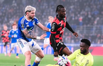 El portero suizo de Lorient, Yvon Mvogo se anticipa al intento ofensivo del delantero paraguayo Julio Enciso del Racing Estrasburgo