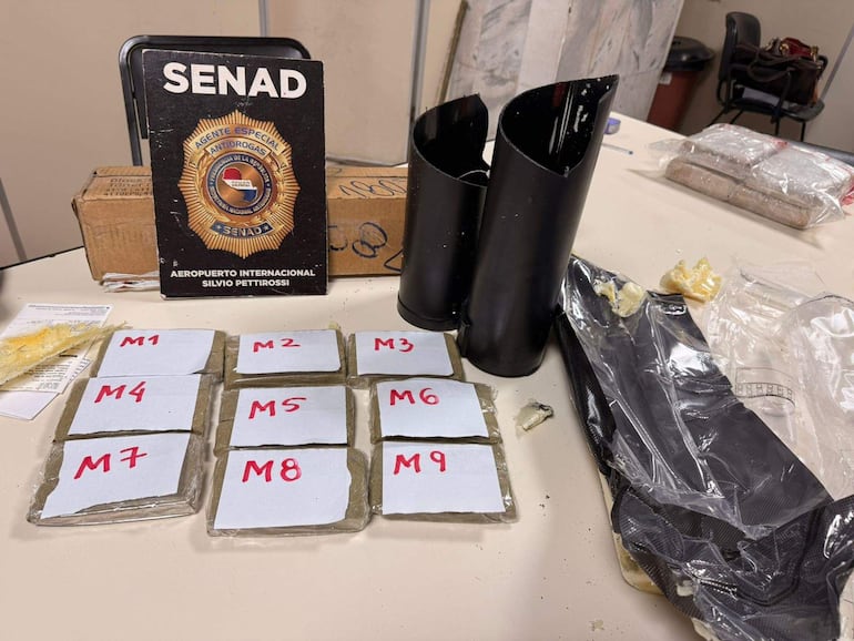 Mesa con insignia de la SENAD, cartuchos de tóner y muestras de marihuana encontradas dentro de los cartuchos de tinta.