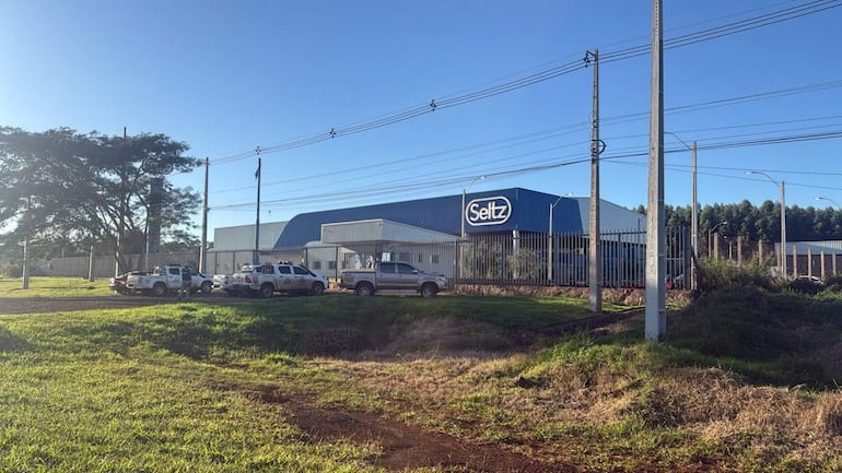 Edificio industrial de Seltz con camionetas estacionadas y un día soleado.