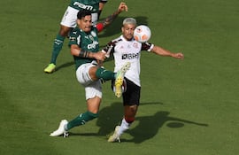 El paraguayo Gustavo Gómez (izq.), del Palmeiras, y el uruguayo Giorgian De Arrascaeta, del Flamengo, disputan el balón durante la final brasileña de la Copa Libertadores.