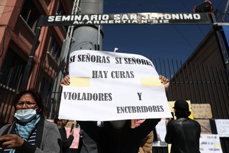 Varias personas protestan en contra de la Iglesia católica pegando carteles en las puertas del seminario San Jerónimo, en La Paz (Bolivia). 