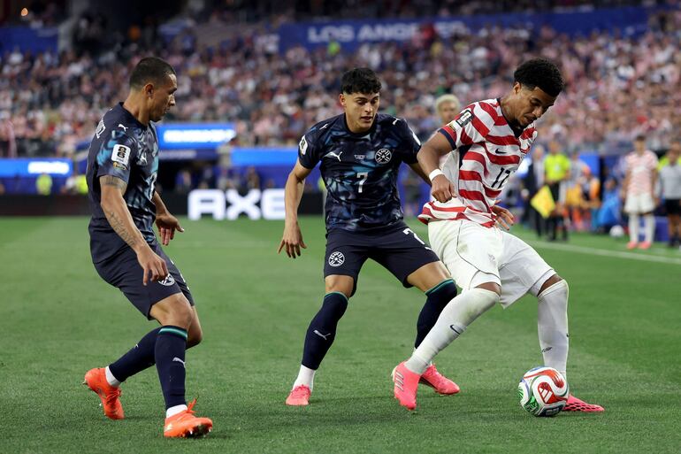 Malik Tillman #17 de los Estados Unidos es disputado por Ramón Sosa #7 de Paraguay durante el partido del Grupo D de la Copa Mundial de la FIFA 2026 entre Estados Unidos y Paraguay en el Los Angeles Stadium en Los Ángeles, California.