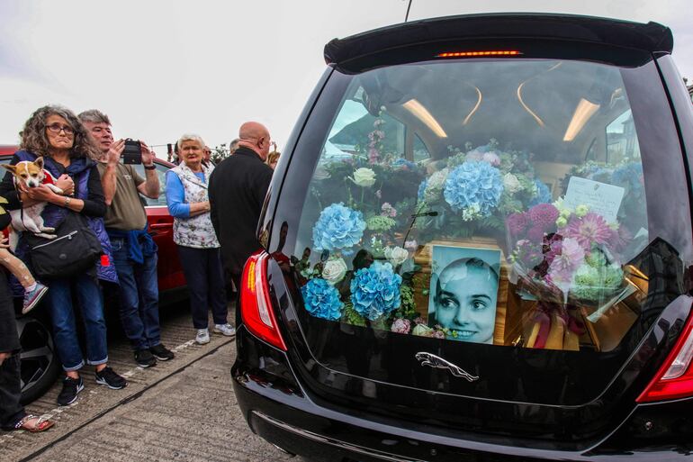 Un retrato de Sinead O'Connor acompaña al féretro con los restos de la cantante fallecida el pasado 26 de julio en Londres.