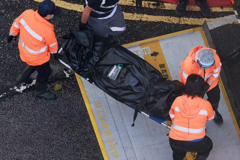 Servicios de emergencia retiran cuerpos de víctimas del incendio en Hong Kong.