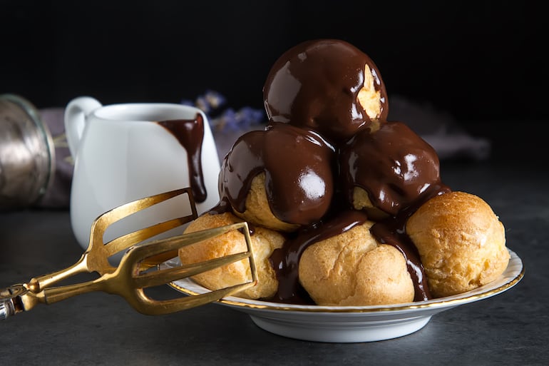 Profiteroles bañados con chocolate amargo.
