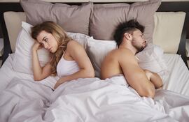 Pareja frustrada en la cama.