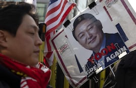 Partidarios del expresidente surcoreano destituido Yoon Suk Yeol sostienen carteles y banderas mientras se manifiestan frente al Tribunal del Distrito Central de Seúl en Seúl, Corea del Sur.