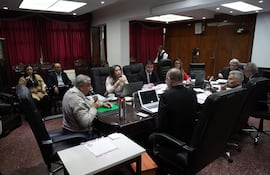 José Emilio Argaña Contreras habla con vaso en mano, mientras mujeres y hombres lo observan con atención en un ambiente formal.