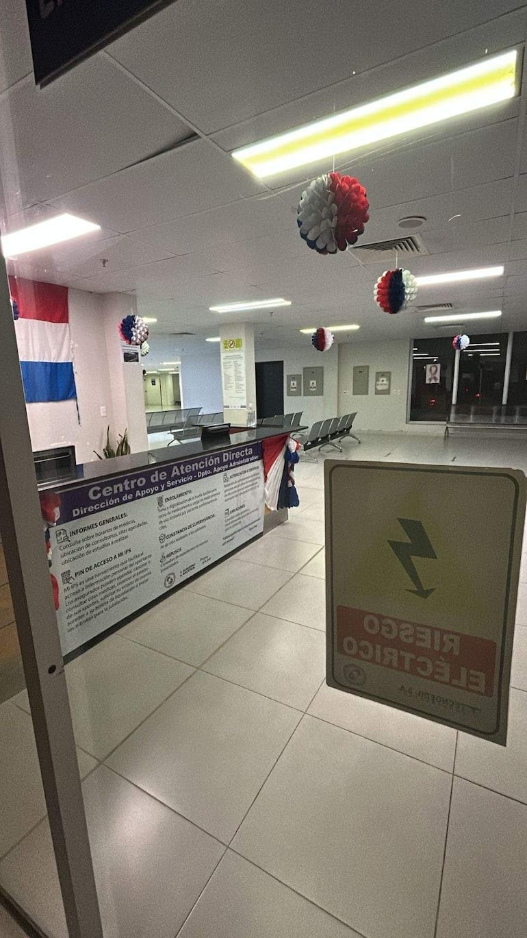 Interiores del centro de atención con decoración en colores de la bandera paraguaya y ambiente vacío.