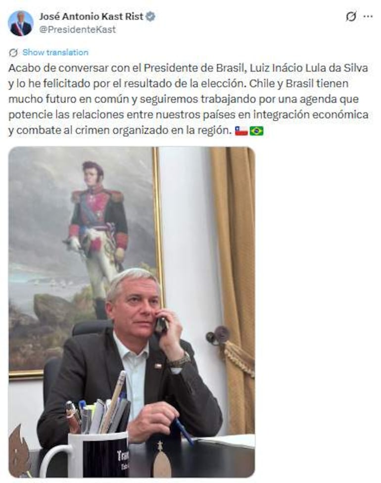 José Antonio Kast Rist sentado en un escritorio, vestido con blazer oscuro, hablando por teléfono con un ambiente formal de oficina.