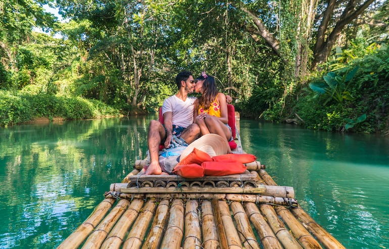 Pareja en un paseo romántico por el río Martha Brae, en balsa de bambú. Montego Bay, Jamaica, Caribe.