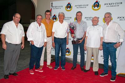 Juan Carlos Aveiro con la copa entregada por el homenajeado Papi Cartasso (2° d.).
