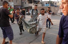 Los palestinos llevan a una víctima al hospital Nasser tras el bombardeo israelí sobre Khan Yunis, en el sur de la Franja de Gaza, en medio del conflicto en curso entre Israel y el grupo militante Hamas.