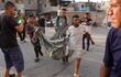 Los palestinos llevan a una víctima al hospital Nasser tras el bombardeo israelí sobre Khan Yunis, en el sur de la Franja de Gaza, en medio del conflicto en curso entre Israel y el grupo militante Hamas.
