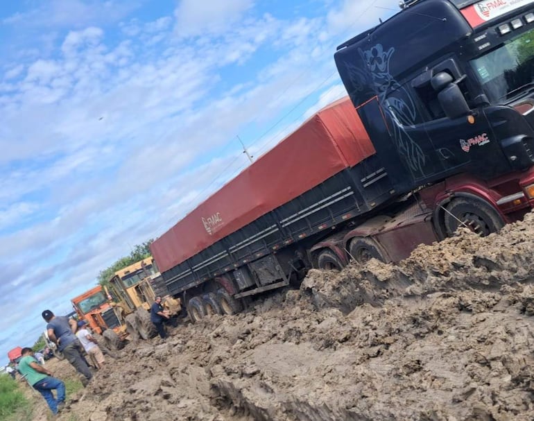 Camiòn atrapado en el barro, es ayudado por tres poderosas maquinarias.