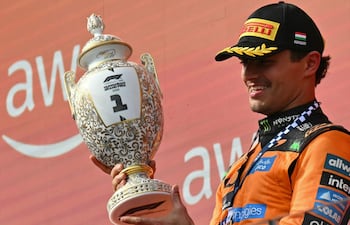 El vencedor del GP de Hungría, el inglés Lando Norris (McLaren), celebra en el podio con su trofeo su primera victoria del año en la F1.