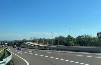 Carretera con señalización y un cartel publicitario de NEUPAR en un día soleado, sin personas visibles.