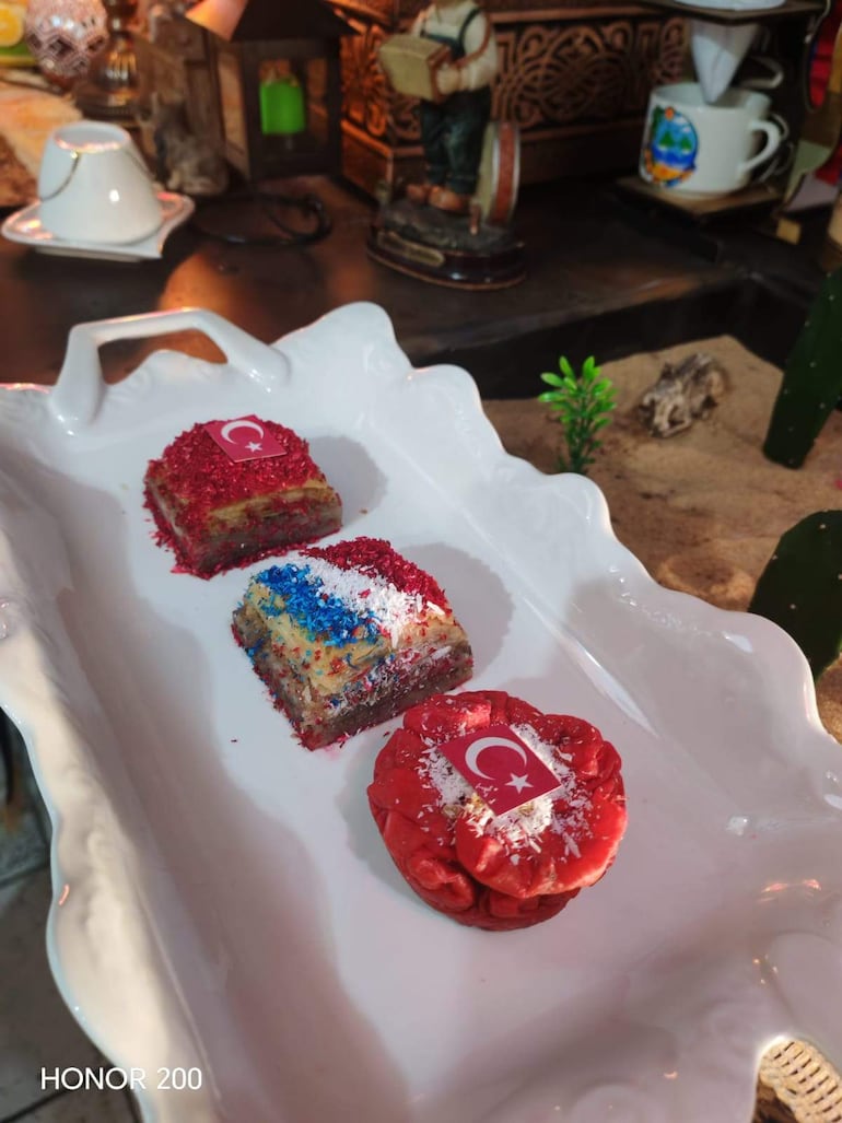 Postres en plato blanco con decoraciones rojas y blancas, evocando la bandera de Turquía, en un ambiente acogedor.