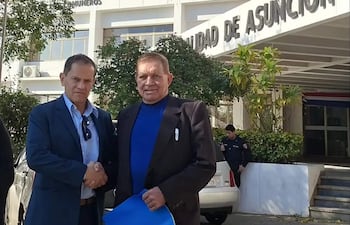 Victorino Soto en chaqueta azul estrecha la mano de Raúl Mongelós, en el exterior de la Municipalidad de Asunción.