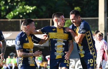 El delantero Fernando Romero celebra su tanto de apertura en el marcador, en medio de Tobías Morínigo y Clementino González.