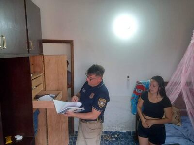 Un efectivo policial busca evidencias durante allanamiento en la casa de Elisa Pino Rojas, quien está bajo sospecha de haber entregado a su pareja a los asaltantes.