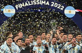 El delantero argentino Lionel Messi levanta el trofeo mientras los jugadores de Argentina celebran en el campo tras su victoria en el partido internacional de fútbol 'Finalissima' entre Italia y Argentina, en el estadio de Wembley, Londres