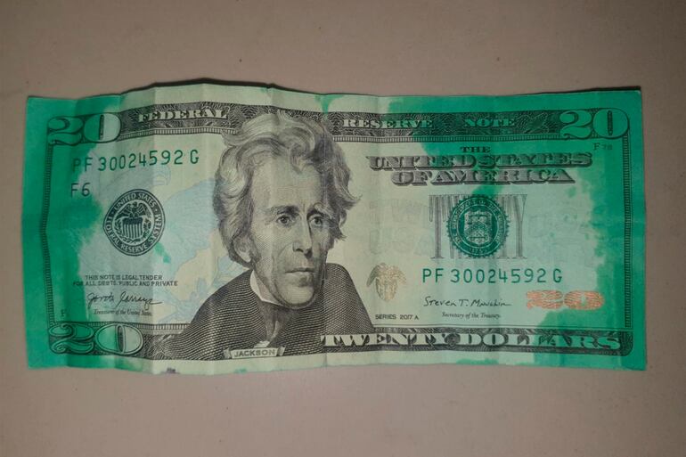 Un billete de 20 dólares manchado con tinta verde, que fue robado en un atraco a un cajero automático de Chile.