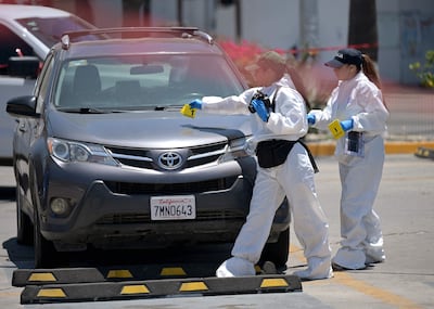Policía forense en plena inspección tras el hallazgo de un cadáver en el maletero del vehículo frente al estadio Caliente de Tijuana, sitio de entrenamiento de la selección de Irán.
