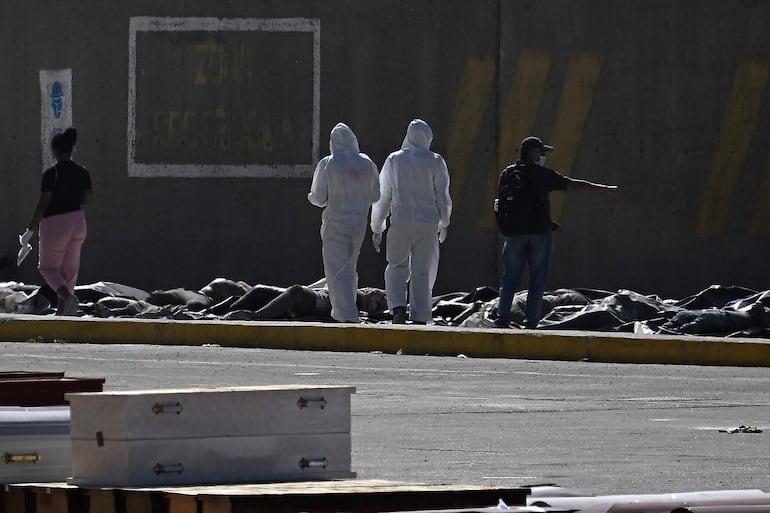 Médicos forenses supervisan la identificación de cadáveres recuperados de entre los escombros, en el puerto de La Guaira. 
