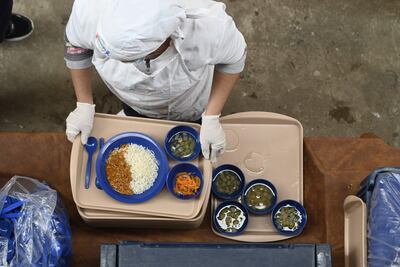 Sirven el almuerzo escolar en el patio de una escuela ante la falta de comedor.