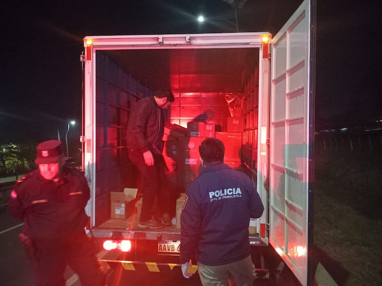 Agentes policiales recolectando evidencias dentro del camión que fue robado.