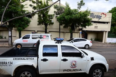Vehiculo de la Policía Nacional y una Ambulancia aguardan frente al motel donde se cometio el asesinato.