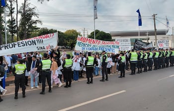 Los médicos se manifiestan en las inmedicaiones de la Conmebol frente a un importante cordón policial.