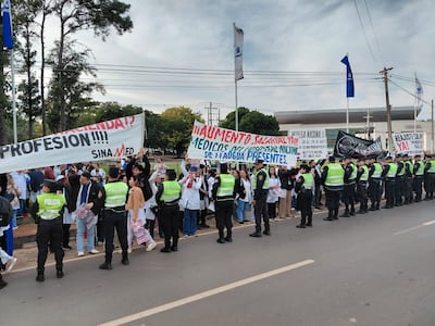 Los médicos se manifiestan en las inmedicaiones de la Conmebol frente a un importante cordón policial.