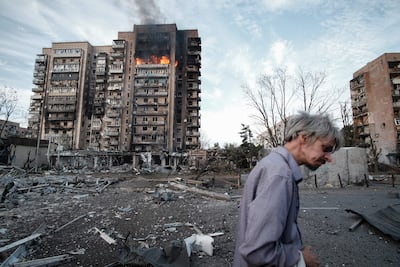 Un hombre camina frente a un edificio en llamas tras un bombardeo ruso en Kramatorsk, en la región ucraniana de Donetsk.