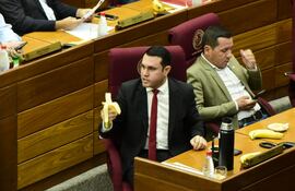 El senador cartista Hernán Rivas come una banana mientras se vota su desafuero. A su lado, su colega Javier "Chaqueñito" Vera se distrae con el celular.
