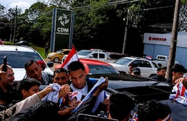 Diego Gómez rodeado de fans con camisetas, algunos levantan teléfonos mientras otros sonríen en el ambiente festivo del evento.