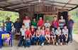 El maestro con sus alumnos y algunos padres que ayudan en el local de la capilla donde se desarrollan las clases, en medio de numerosas carencias.