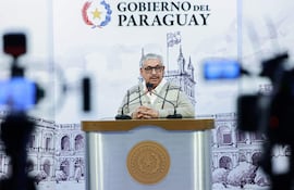 Isaías Ricardo Fretes en podio, con gafas y suéter claro, habla ante cámaras en el Palacio de López.