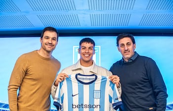 El defensor, Matías Damián Pérez, en su presentación como nuevo jugador de Racing de Avellaneda, en medio de Sebastián Saja (director deportivo) y Diego milito (presidente).