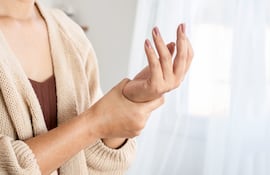 Mujer sufre de dolores por artritis.