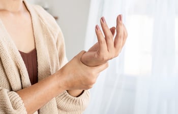 Mujer sufre de dolores por artritis.