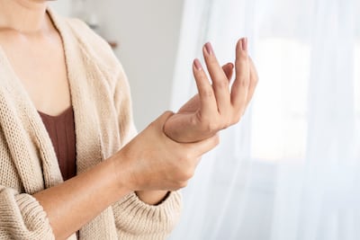 Mujer sufre de dolores por artritis.